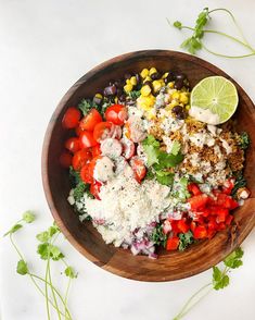 a wooden bowl filled with different types of food and garnished with cilantro