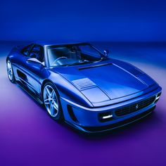 a blue sports car parked in front of a purple background