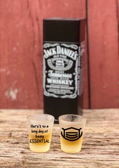 two shot glasses sitting on top of a wooden table