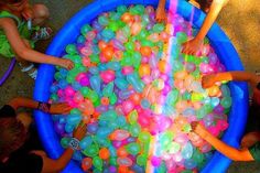 children playing with water beads in a blue tub