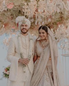 a man and woman standing next to each other under a chandelier