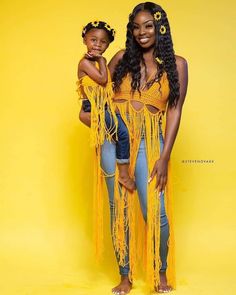 two women in yellow outfits posing for the camera with one woman holding her hand on her hip