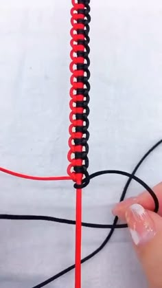 a hand holding a red and black wire