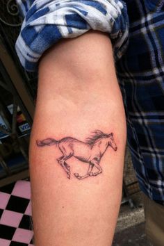 a person with a horse tattoo on their leg