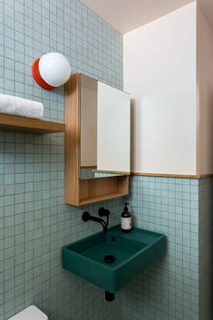 a green sink in a bathroom next to a white toilet