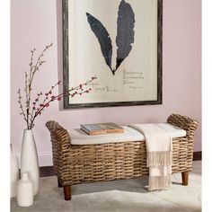 a wicker bench in front of a painting and vases