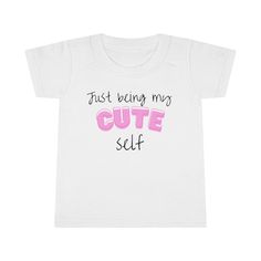 What the perfect gift for your toddlers? This effortless statement merch that says, 'Just Being My Cute Self' is the most adorable present you can ever gift to your kids, nephews, and nieces this coming Christmas season! This cute design comes in blue and pink for boys and girls respectively, printed in shirts, hoodies, caps, tote bags, and mugs. Product Information: Gildan 64500P *100% Ringspun cotton (fiber content may vary for different colors) *Light fabric (4.5 oz/yd² (153 g/m *Classic Fit *Grey pearlized tear-away label Care Instructions:  *Machine wash: cold (max 30C or 90F) *Non-chlorine: bleach as needed. *Tumble dry: low heat; Iron, steam or dry *Do not dry clean. If you like this Toddler T-shirt please check out our store for other designs. We're hard at working  adding new desi Christmas Gift For Kids, Clothing Black, Top Baby Products, Children Clothing, Gift For Kids, Christmas Tees, Christmas Gifts For Kids, Gender Neutral Baby, Christmas Season