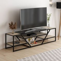 a flat screen tv sitting on top of a wooden stand