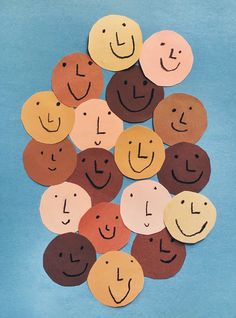 a pile of paper circles with faces drawn on them in the shape of letters and numbers