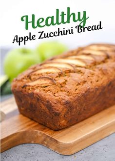 a loaf of apple zucchini bread sitting on top of a wooden cutting board