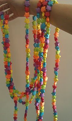 a person holding up a multi - colored beaded necklace