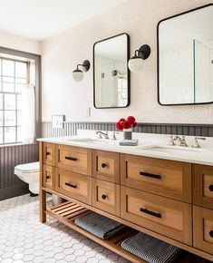 a bathroom with two sinks and mirrors on the wall