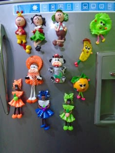 there are many toy figures hanging on the refrigerator door and magnets attached to it