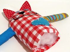 a red and white checkered bag with a cat on it next to a blue toothbrush