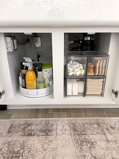 an area rug in the middle of a white cabinet with drawers and items on it