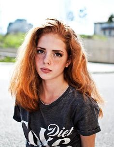 a woman with red hair sitting on the ground