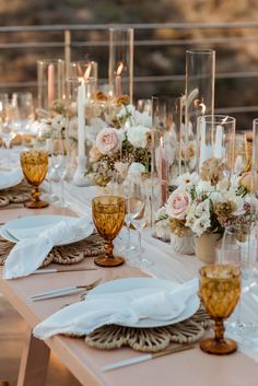 the table is set with candles, flowers and napkins for an elegant wedding reception