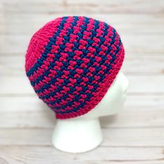 a crocheted hat on a mannequin's head is shown in red and blue