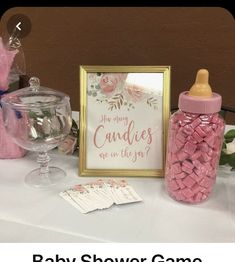 a baby shower table with pink candies in a jar and a sign that says, are you any candles up on the way?