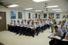 a group of people sitting in front of desks with papers and pencils on them