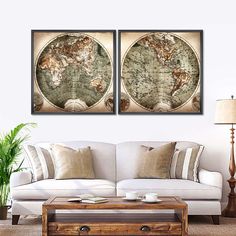 two framed maps on the wall above a couch in a living room with a coffee table