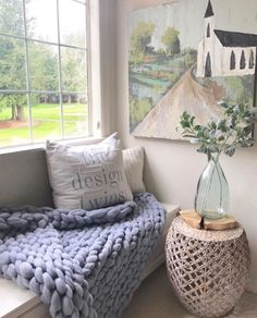 a blue blanket sitting on top of a window sill next to a vase filled with flowers