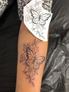 a woman's arm with a butterfly tattoo on the left side of her arm