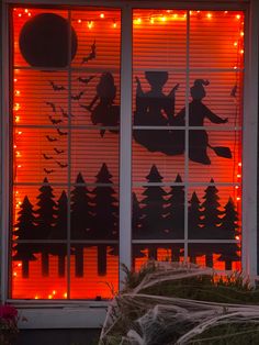 the window is decorated with silhouettes of people riding on sleighs and bats