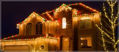 a house with christmas lights on it and a truck parked in front of the house