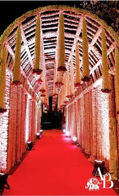 a red carpeted walkway is lit up with white lights and garlands on the sides