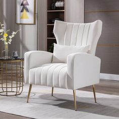 a white chair sitting in a living room next to a vase with flowers on it