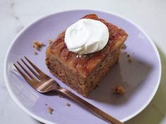 a piece of cake on a purple plate with a fork and knife next to it