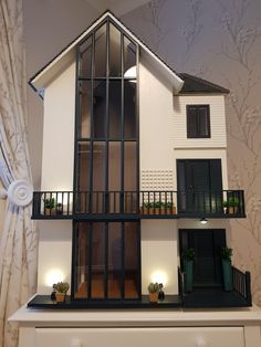 a doll house with windows and balconies on the top floor is lit up