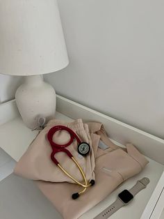 a pair of red scissors and a stethoscope sit on top of a bed