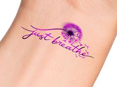 a dandelion tattoo with the word just breathe on it's side, in purple ink