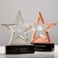 two star shaped award plaques sitting next to each other