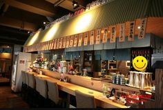 a bar with lots of bottles on it and a smiley face painted on the wall