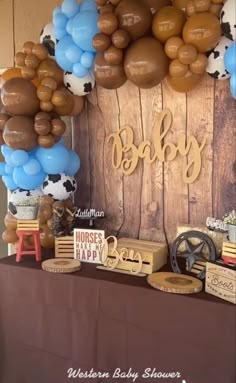 a table topped with lots of balloons and other items on top of a wooden wall