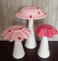 three pink and white vases sitting next to each other on top of a table