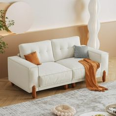 a white couch sitting on top of a wooden floor next to a table with food