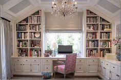 a room with a desk, bookshelf and chandelier