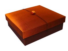 an orange box with a string tied around the top and bottom, on a white background