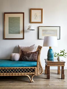 a living room with wicker furniture and pictures on the wall above it's couch