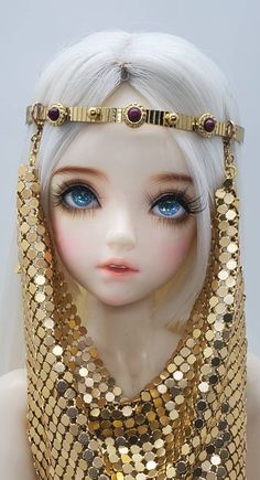 a mannequin headpiece with gold sequins and jewels on it's face