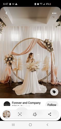 a woman standing in front of a wedding arch with flowers and feathers on the wall