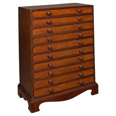 a wooden dresser with many drawers and knobs on the bottom drawer, against a white background