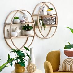 two circular shelves with plants on them in front of a white wall and a yellow chair