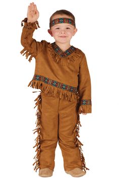 a young boy dressed in native american clothing and holding his hand up to the sky