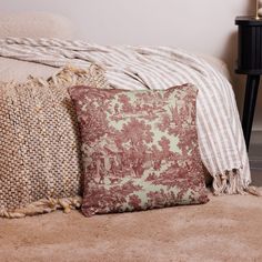 two pillows sitting on top of a bed next to a lamp