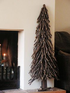 a wooden christmas tree next to a fireplace